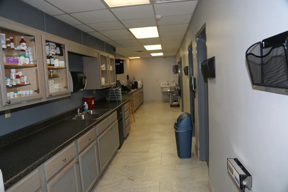 Photo of Animal Care Center of Tupelo Location Back of Office, includes a hallway with cabinets filled with supplies as well as a sink in the background and other items